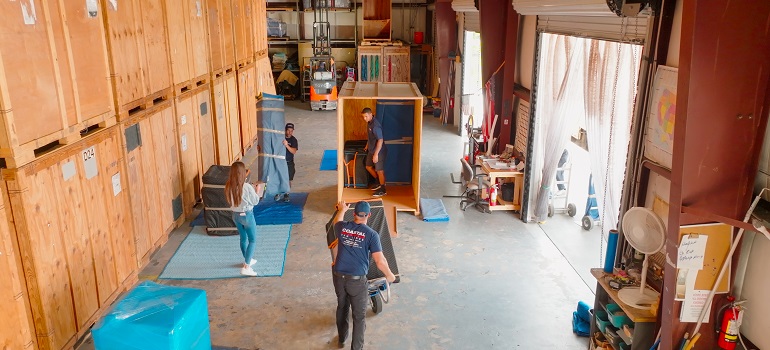 a team of movers helping someone pack medical equipment for a long distance move
