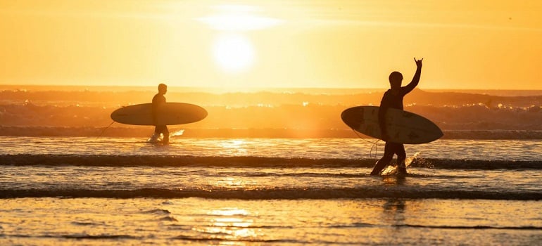 a couple surfing in one of the affordable neighborhoods to live in St Lucie County