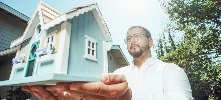 a man holding a model of ahome 