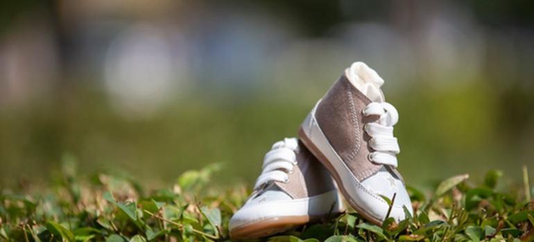 Toddler shoes on grass in a family-friendly park.